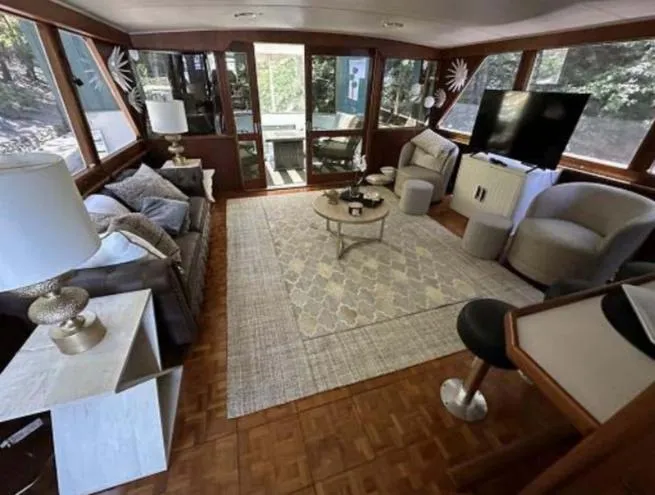 Slide: The Image of 1976 Chris-Craft Roamer yacht interior with modern furnishings and large windows. - 10