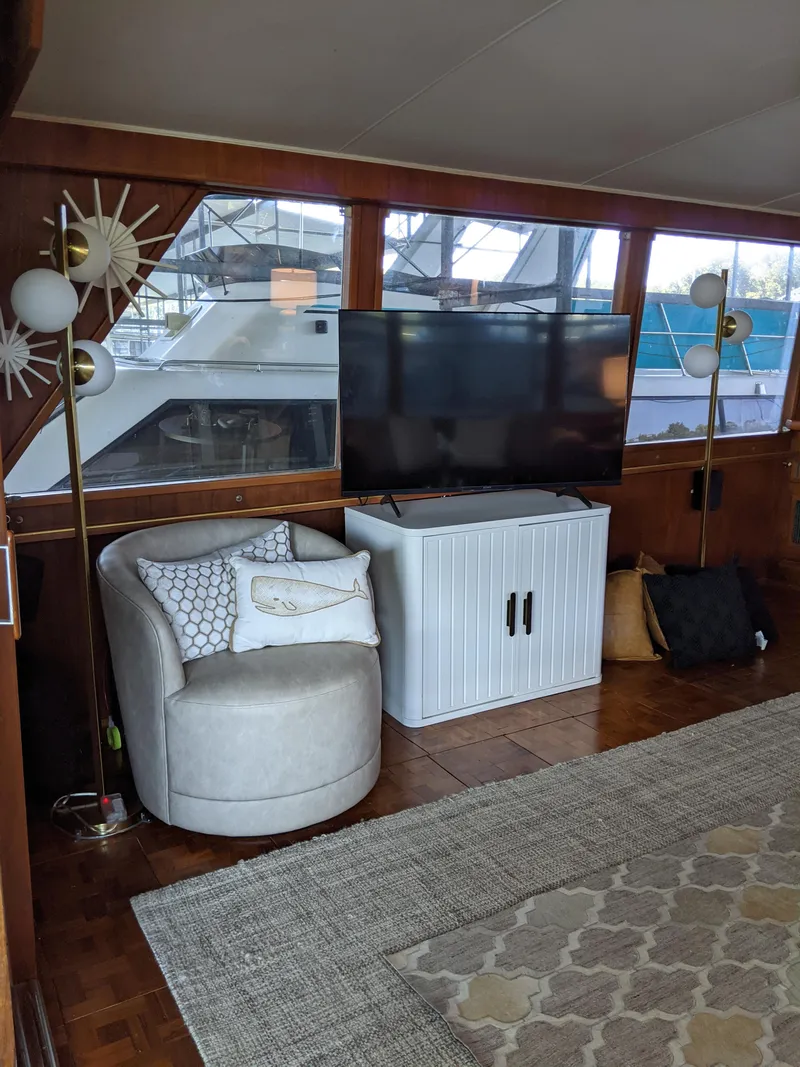 Slide: The Image of Interior of a 1976 Chris-Craft Roamer yacht with modern furnishings and a flat-screen TV. - 13