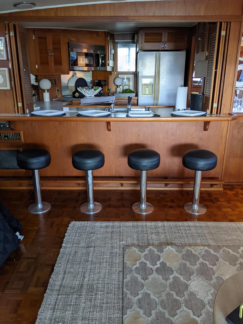 Slide: The Image of 1976 Chris-Craft Roamer yacht interior with kitchen and bar stools. - 16