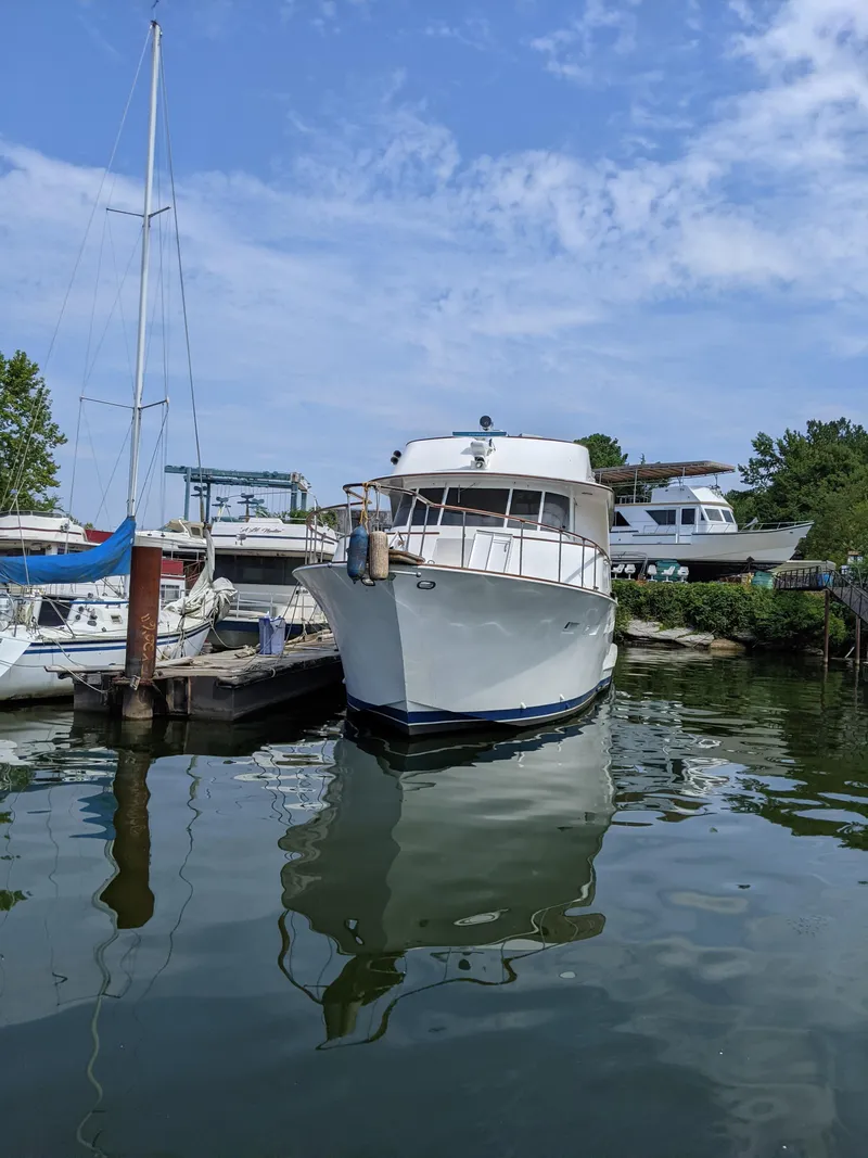Slide: The Image of 1976 Chris-Craft Roamer yacht docked at a marina on a sunny day. - 2
