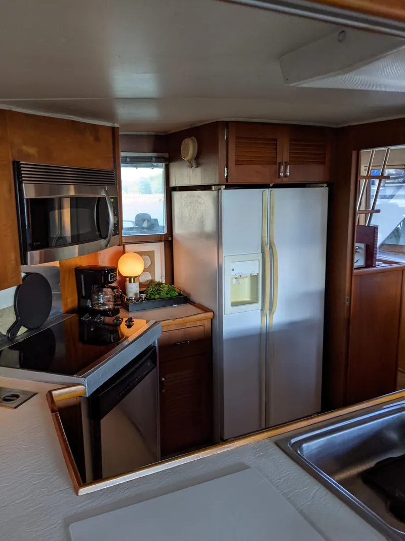 Slide: The Image of 1976 Chris-Craft Roamer kitchen with modern appliances, including a refrigerator, microwave, and coffee maker. - 23