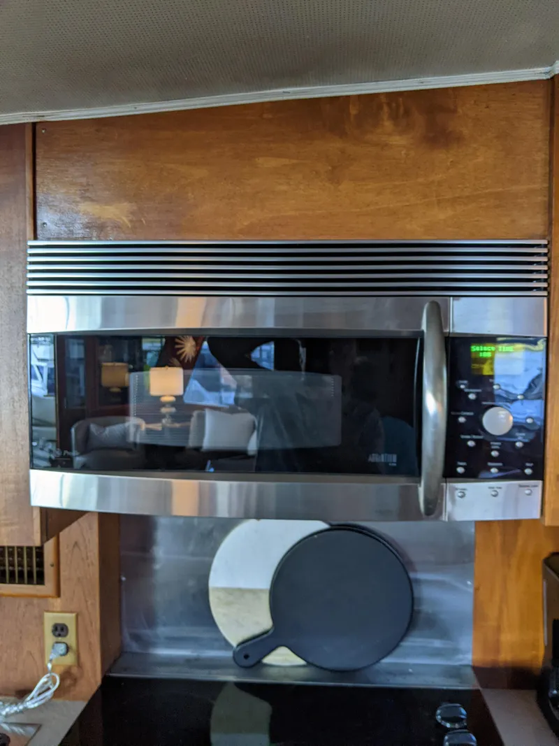 Slide: The Image of 1976 Chris-Craft Roamer kitchen with stainless steel microwave and wooden cabinetry. - 26