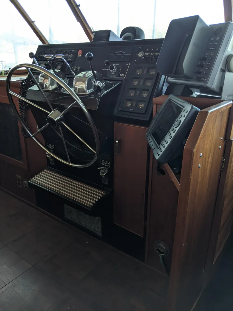 Slide: The Image of 1976 Chris-Craft Roamer boat helm with steering wheel and navigation equipment. - 28