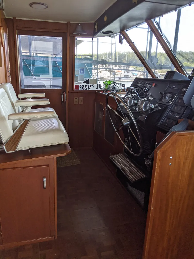 Slide: The Image of 1976 Chris-Craft Roamer boat interior with helm station and white captain chairs. - 29