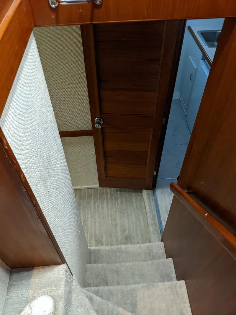 Slide: The Image of Interior stairs of a 1976 Chris-Craft Roamer yacht leading to a wooden door. - 39