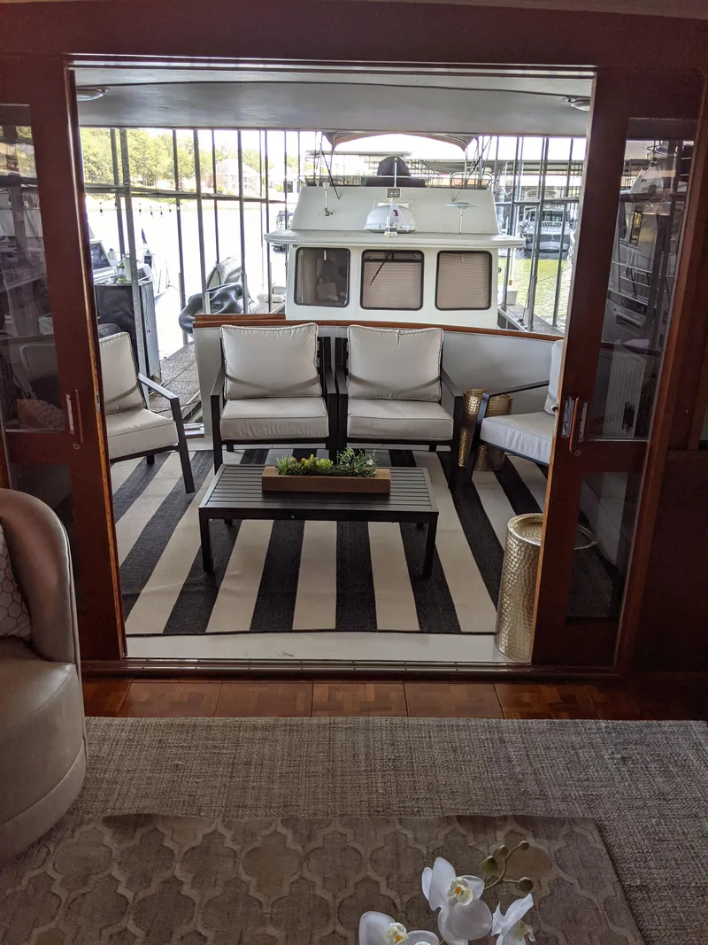 Slide: The Image of 1976 Chris-Craft Roamer yacht with stylish outdoor seating area and striped rug. - 4