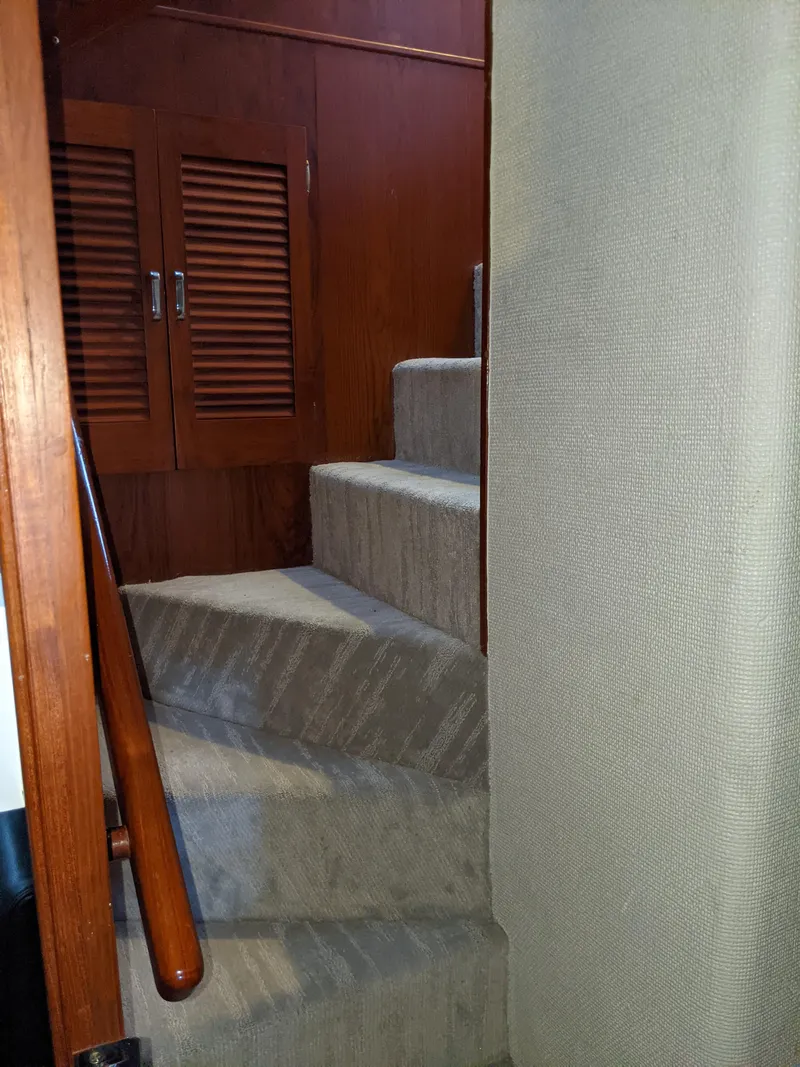 Slide: The Image of Interior stairs of a 1976 Chris-Craft Roamer yacht with wooden accents. - 40