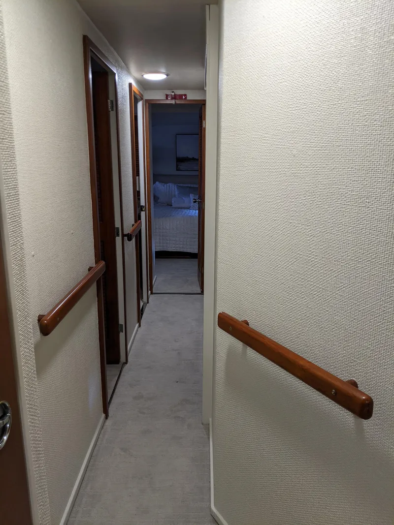 Slide: The Image of 1976 Chris-Craft Roamer yacht interior hallway with wooden handrails. - 42