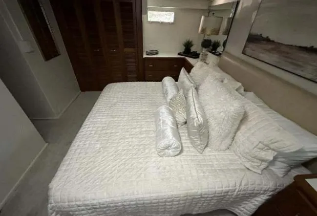 Slide: The Image of Luxurious bedroom interior of a 1976 Chris-Craft Roamer yacht with white bedding. - 45