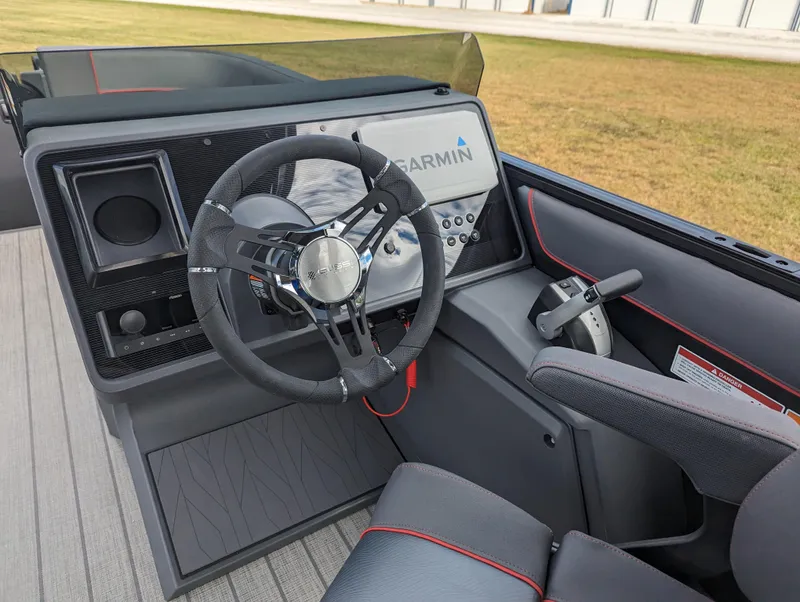 Slide: The Image of 2024 Manitou Explore 22 MAX boat cockpit with Garmin navigation system and steering wheel. - 10