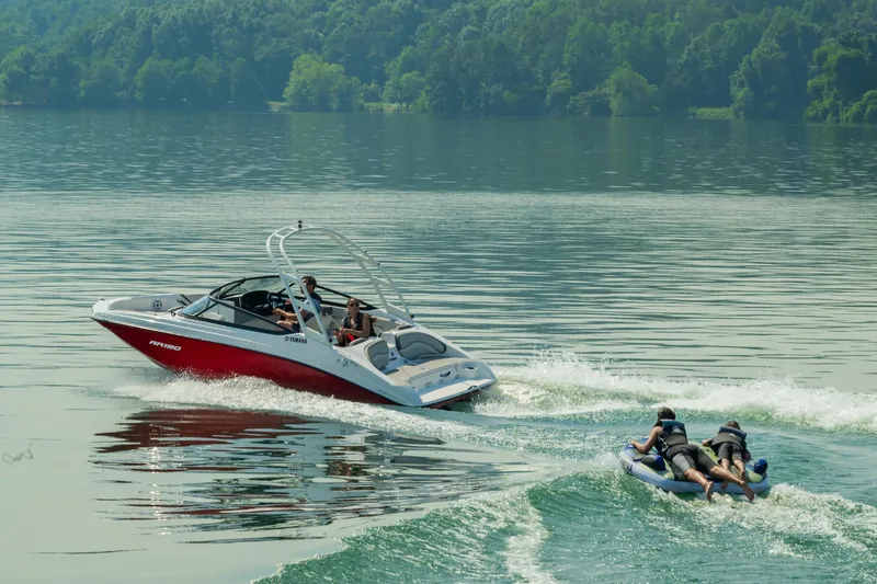Slide: The Image of 2024 Yamaha Boats AR190 towing people on an inflatable tube on a lake. - 11