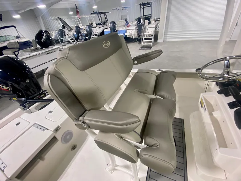 Slide: The Image of 2024 Key West 230 Bay Reef boat interior with dual captain's chairs in showroom. - 13
