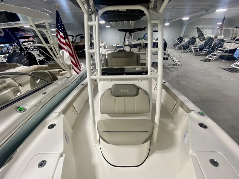 Slide: The Image of 2024 Key West 230 Bay Reef boat interior in showroom, featuring seating and storage. - 19
