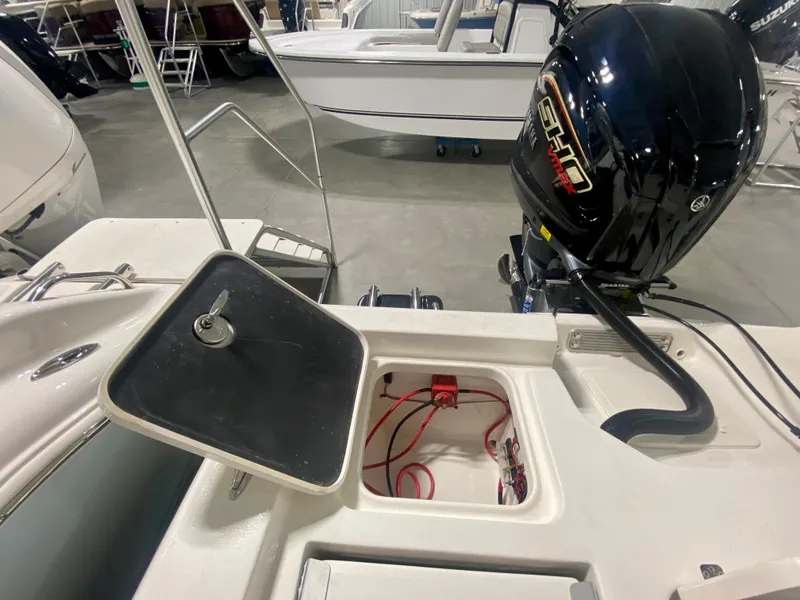 Slide: The Image of 2024 Key West 230 Bay Reef boat with open storage compartment and outboard motor. - 8