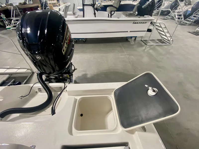 Slide: The Image of 2024 Key West 230 Bay Reef boat with open storage compartment and Suzuki outboard motor. - 10