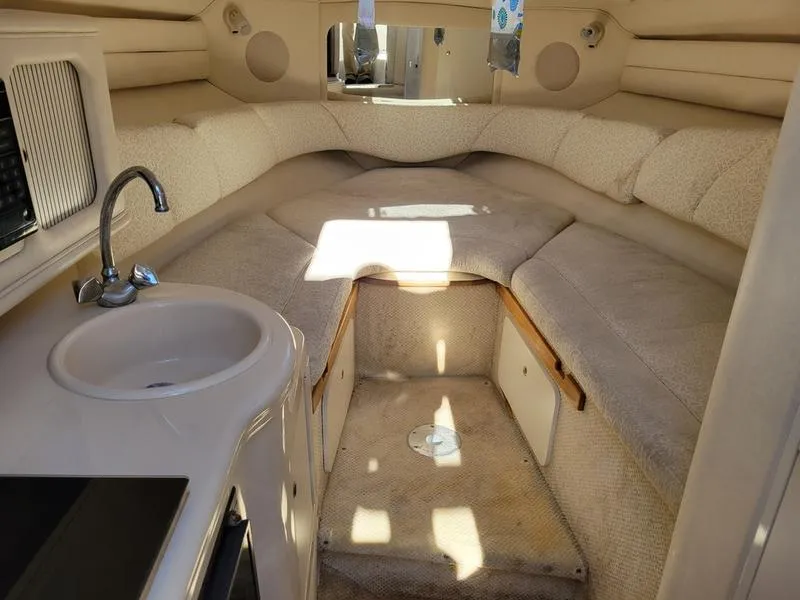 Slide: The Image of Interior of 2001 Sea Ray 26' Sundancer boat with cozy seating and compact kitchenette. - 18