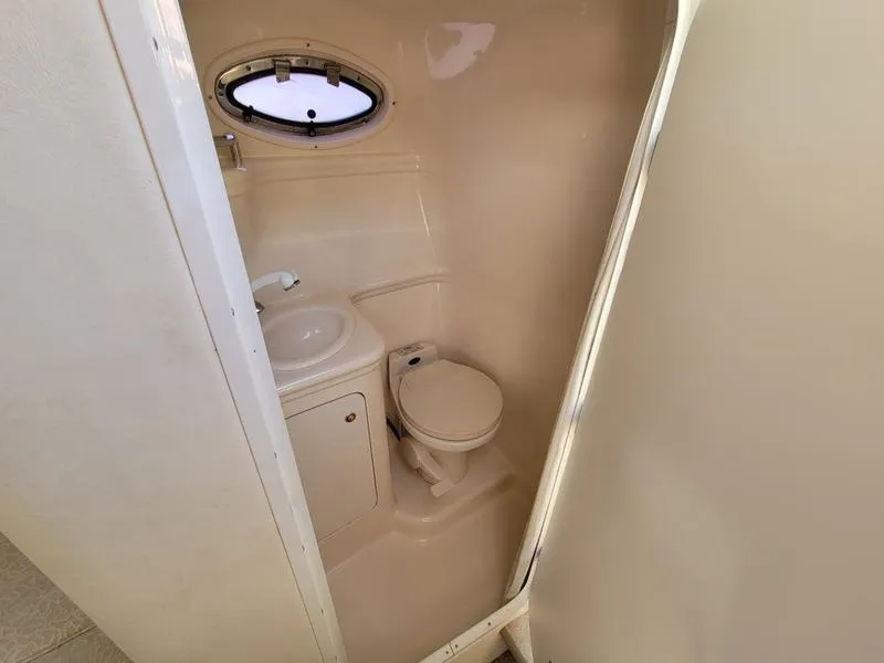 Slide: The Image of Compact bathroom in 2001 Sea Ray 26' Sundancer boat with toilet and sink. - 22