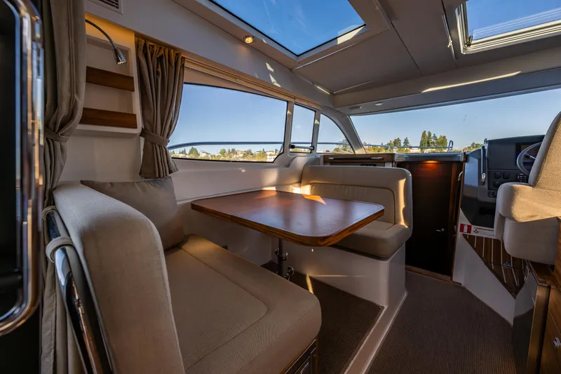 Slide: The Image of Interior of 2016 Nimbus 305 Coupe with dining area and panoramic windows. - 12