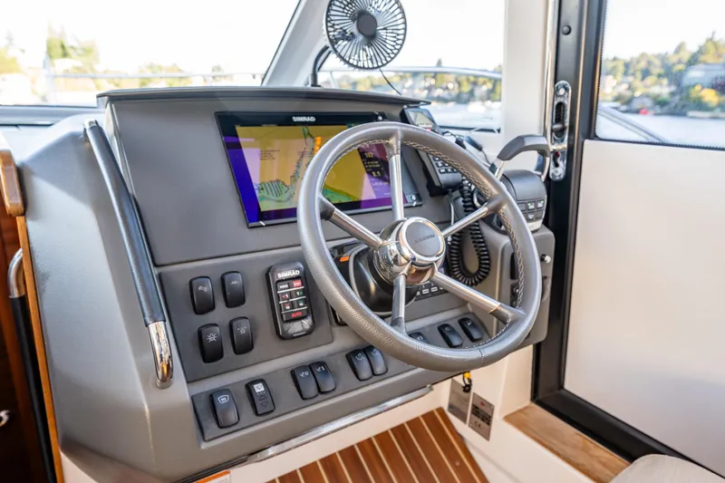 Slide: The Image of Steering console of 2016 Nimbus 305 Coupe with navigation display and control switches. - 8