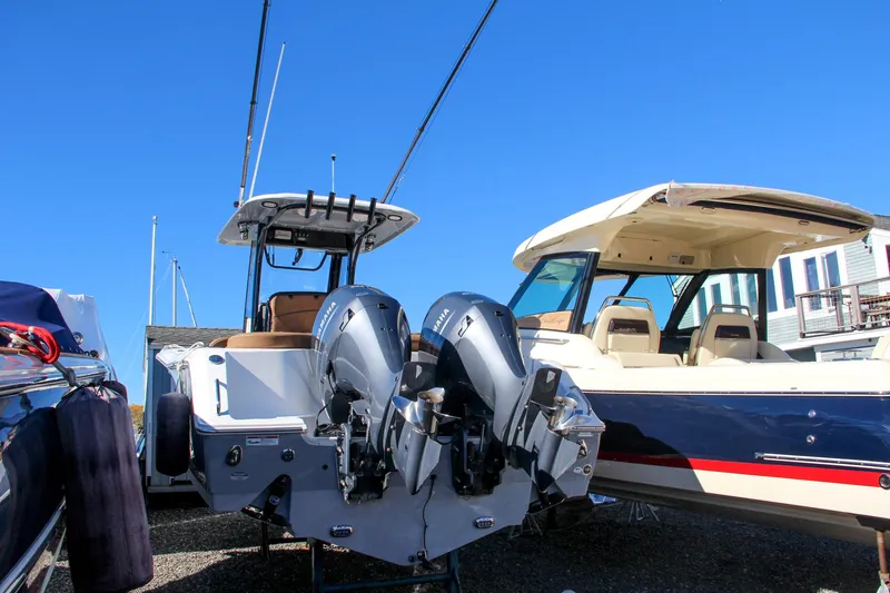 Slide: The Image of 2021 Sea Hunt Ultra 275 SE with dual outboard motors in a marina. - 1