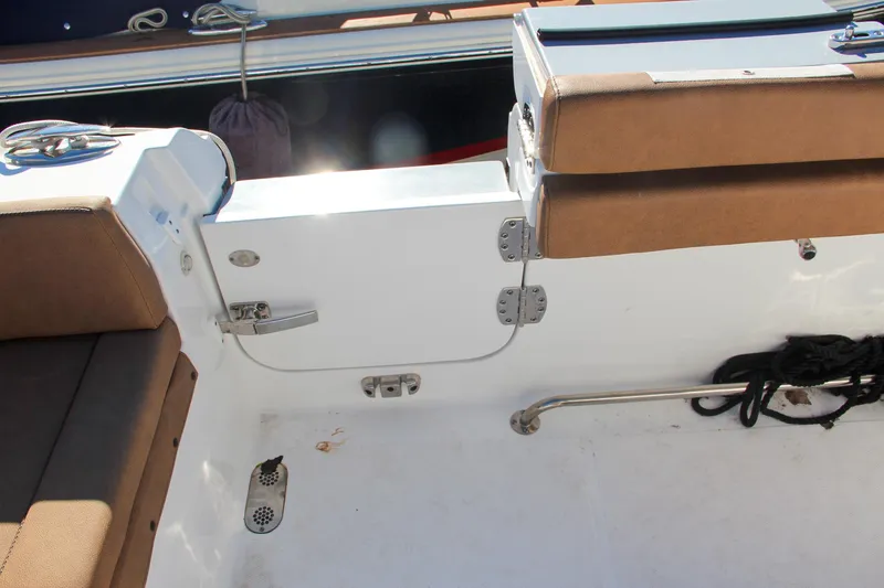 Slide: The Image of 2021 Sea Hunt Ultra 275 SE boat interior with brown seating and white deck. - 22