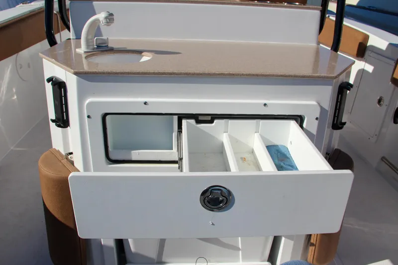 Slide: The Image of 2021 Sea Hunt Ultra 275 SE boat with open storage drawer and sink. - 27