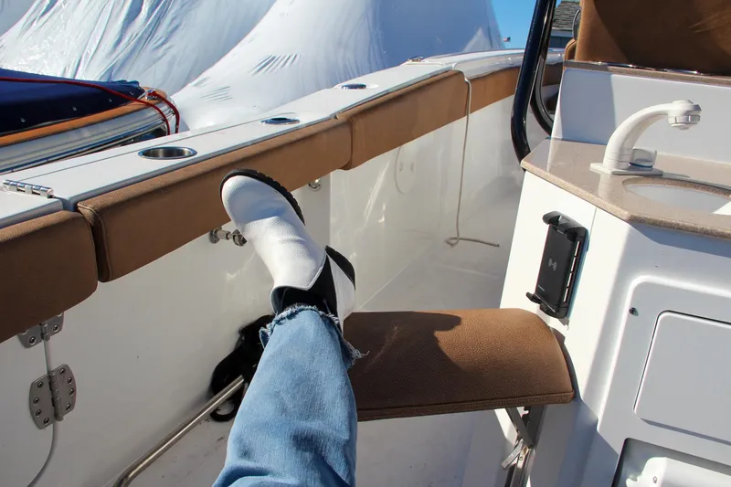 Slide: The Image of Person relaxing on a 2021 Sea Hunt Ultra 275 SE boat with feet up. - 30