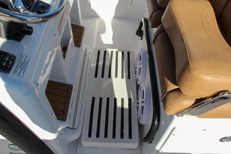 Slide: The Image of 2021 Sea Hunt Ultra 275 SE helm station with brown seating and footrest. - 40