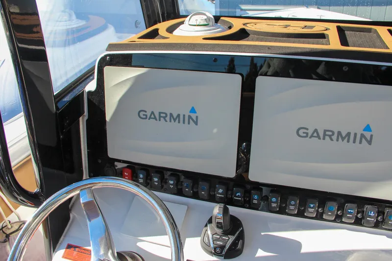 Slide: The Image of 2021 Sea Hunt Ultra 275 SE dashboard with dual Garmin displays and steering wheel. - 49