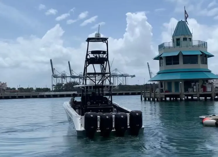 Slide: The Image of 2014 Hydra-Sports Siesta boat with quad engines near a marina and waterfront building. - 11