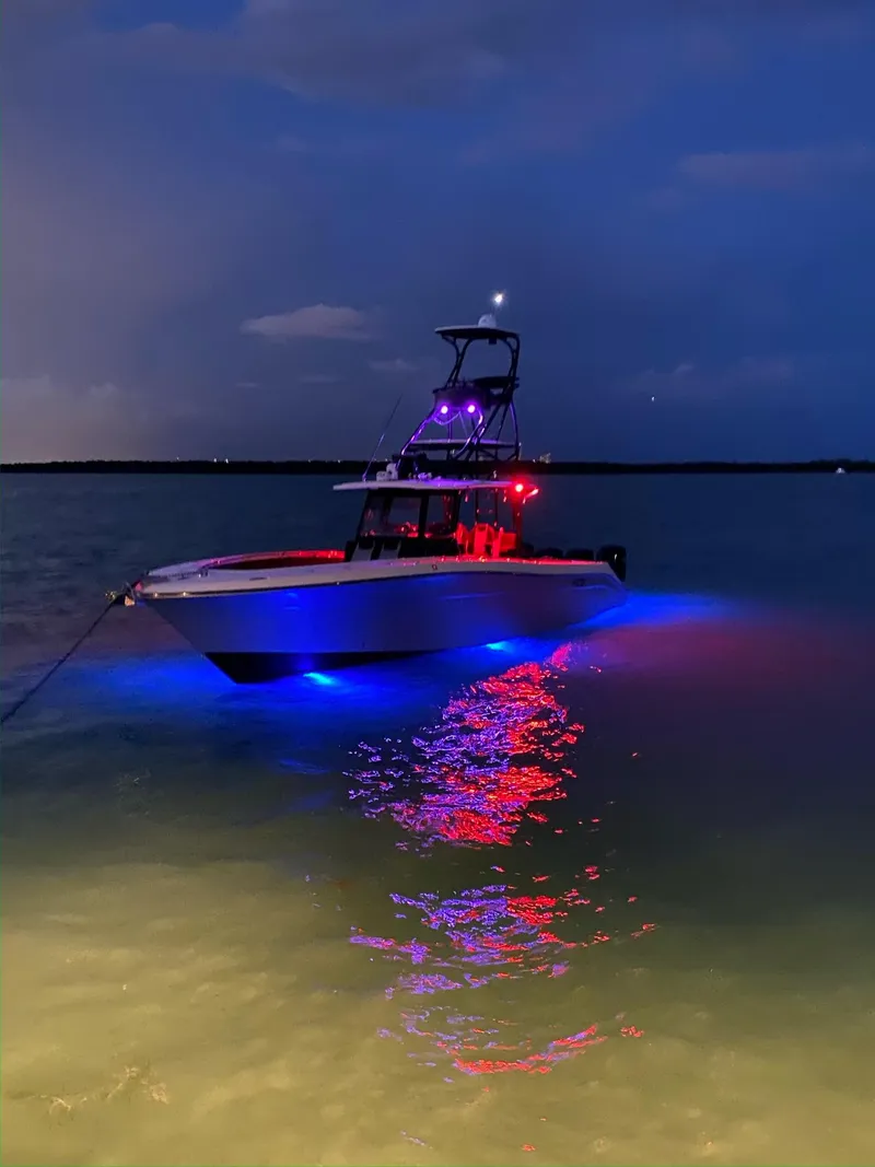 Slide: The Image of 2014 Hydra-Sports Siesta boat illuminated with colorful lights at night on the water. - 15
