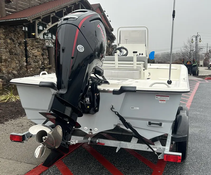 Slide: The Image of 2024 Mako Pro Skiff 19 CC boat on trailer, featuring powerful outboard motor. - 1