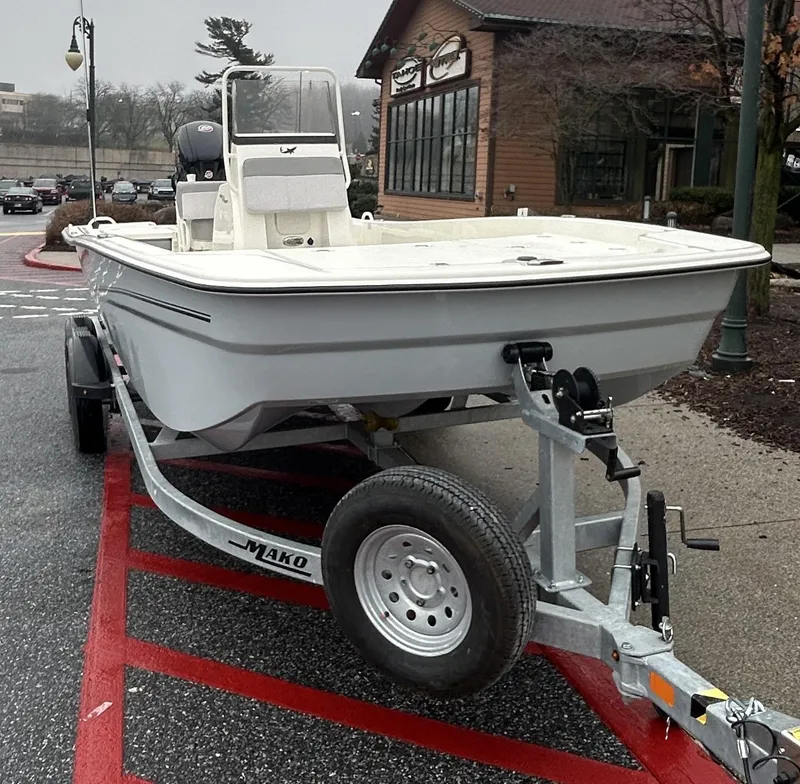 Slide: The Image of 2024 Mako Pro Skiff 19 CC boat on trailer in parking lot. - 2