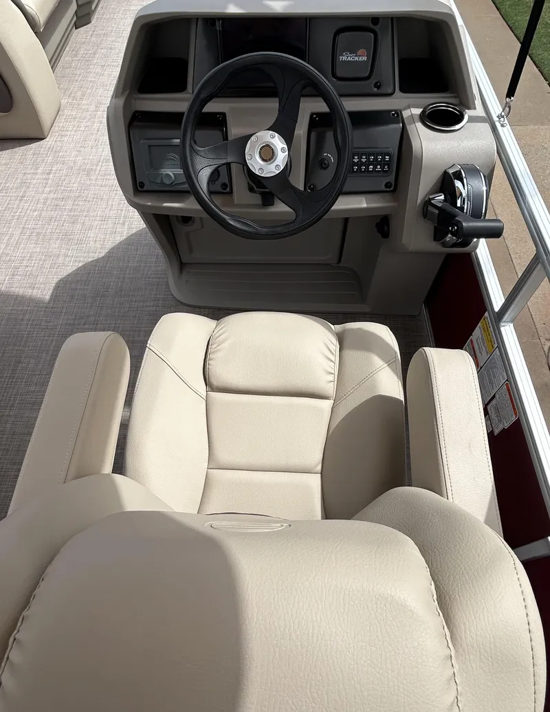 Slide: The Image of 2024 Sun Tracker Party Barge 18 DLX helm with beige captain's chair and steering console. - 5