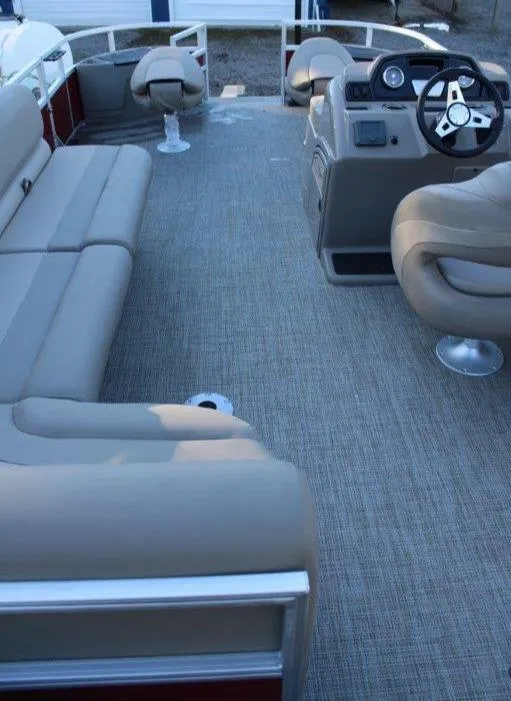 Slide: The Image of 2024 Ranger Reata 200F pontoon boat interior with beige seating and steering console. - 5