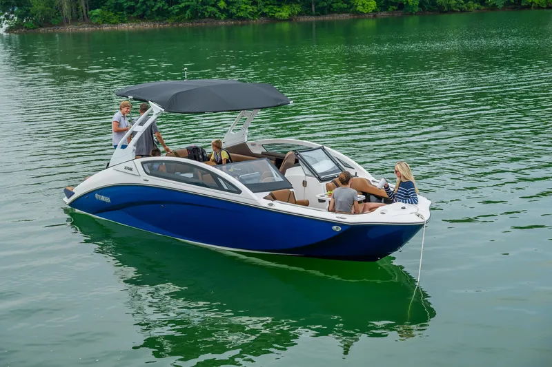 Slide: The Image of 2024 Yamaha Boats 275SE on a serene lake with passengers enjoying the ride. - 10