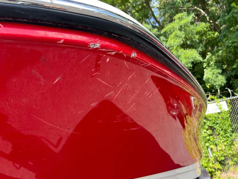 Slide: The Image of Red 2021 Sea Ray SPO 210 boat with visible scratches on the hull. - 13