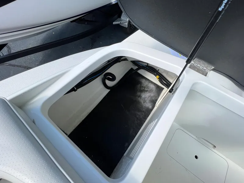Slide: The Image of 2021 Sea Ray SPO 210 storage compartment with open lid, showcasing interior space. - 8