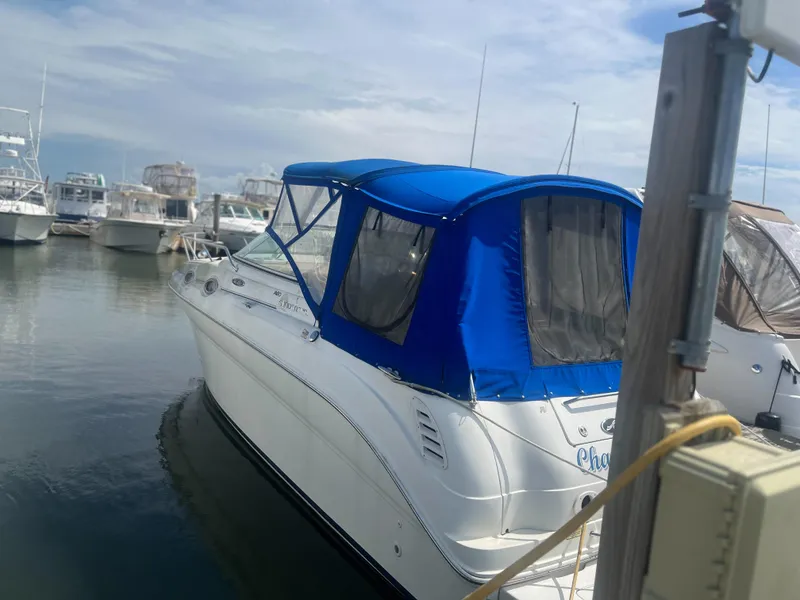 The Image of 2002 Sea Ray 260 Sundancer with blue canopy docked at marina. - 0