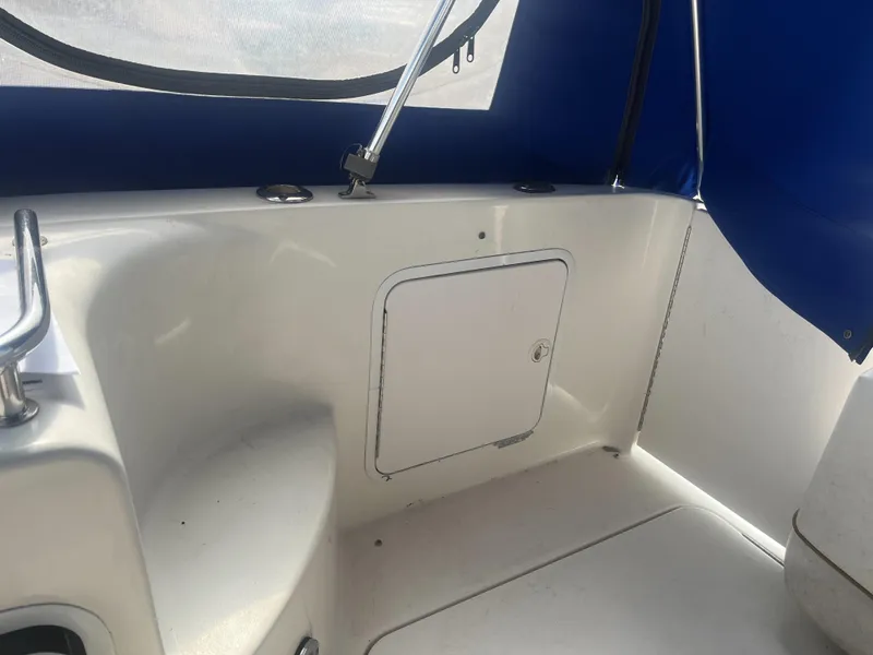 Slide: The Image of 2002 Sea Ray 260 Sundancer interior with storage compartment and blue canopy. - 21