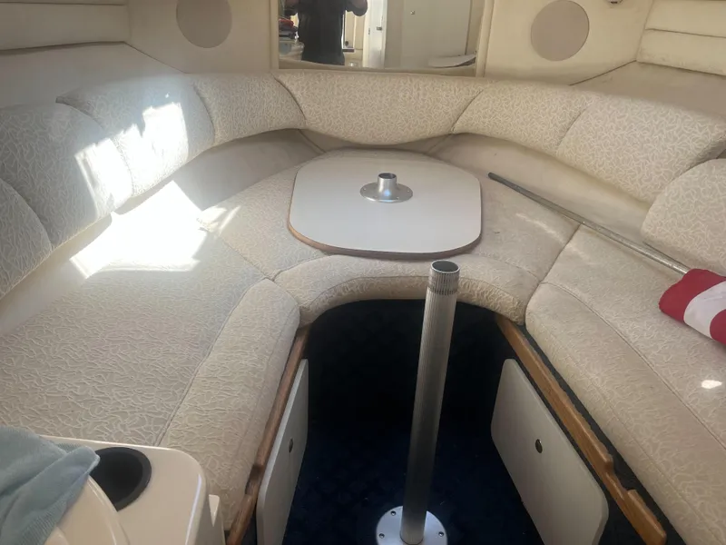 Slide: The Image of Interior of a 2002 Sea Ray 260 Sundancer boat with cushioned seating and table. - 4