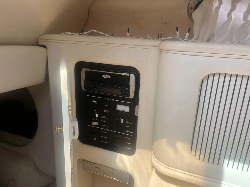 Slide: The Image of 2002 Sea Ray 260 Sundancer cabin interior with control panel and storage compartment. - 5
