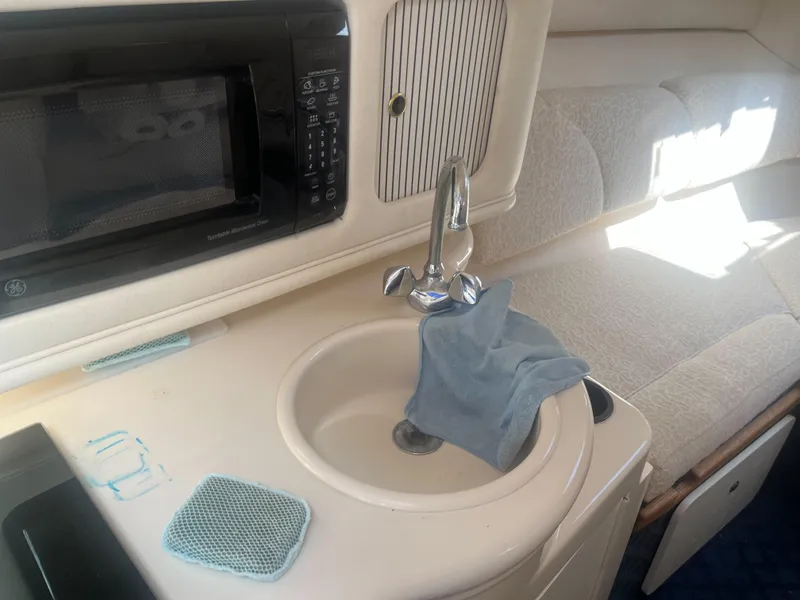 Slide: The Image of Interior of 2002 Sea Ray 260 Sundancer with sink, microwave, and seating area. - 6