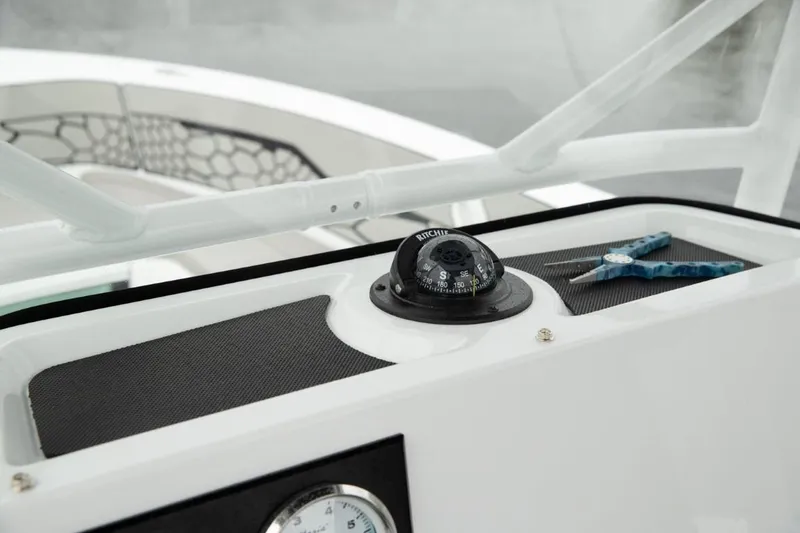 Slide: The Image of 2024 Wellcraft 202 Fisherman boat dashboard with compass and pliers. - 16