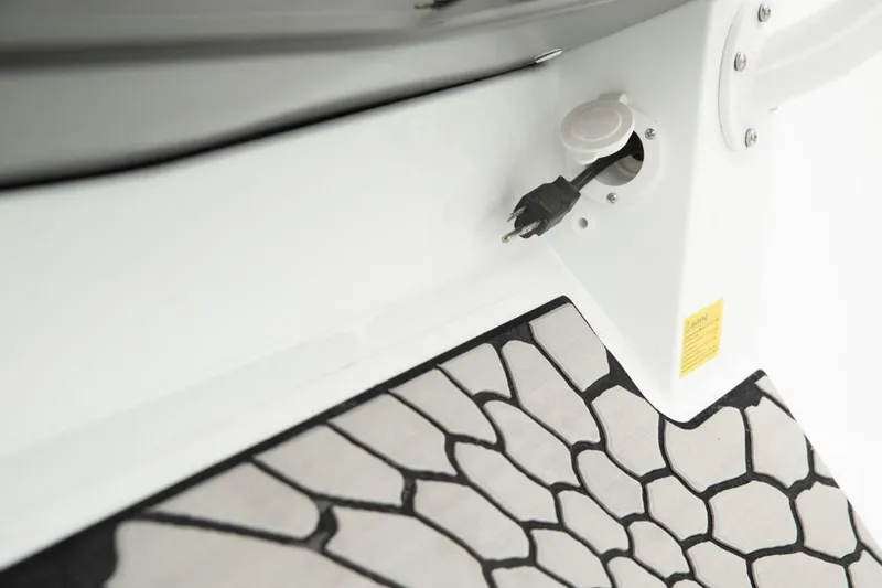 Slide: The Image of Close-up of the 2024 Wellcraft 202 Fisherman boat's electrical outlet and deck. - 17