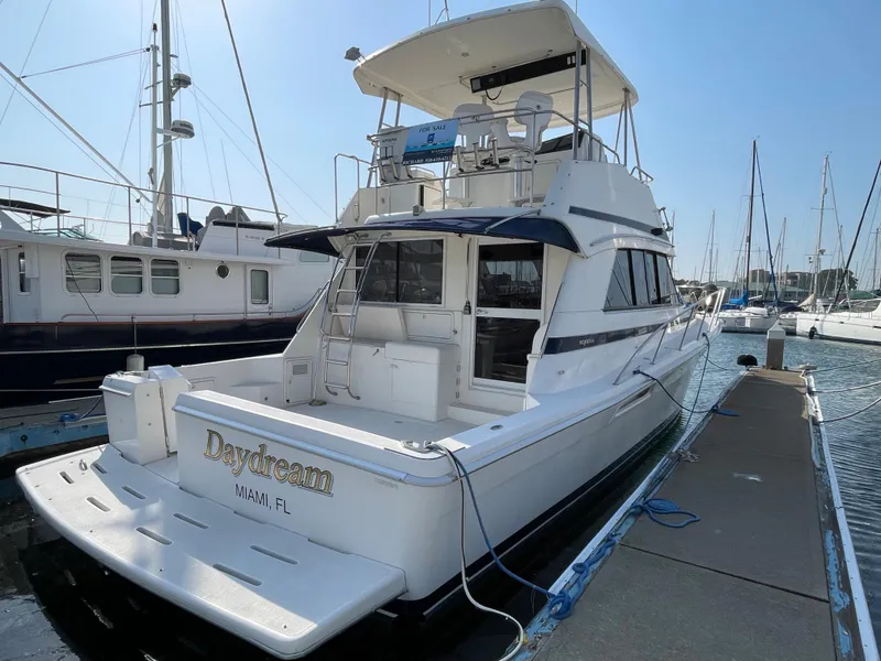 The Image of 2000 Riviera Flybridge yacht docked at marina, rear view, sunny day. - 0