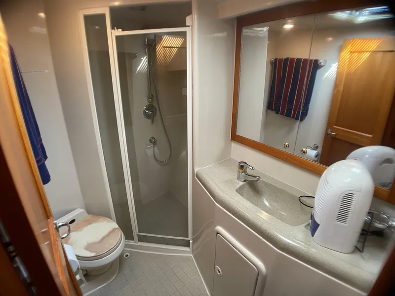 Slide: The Image of Bathroom interior of 2000 Riviera Flybridge yacht with shower, sink, and toilet. - 12