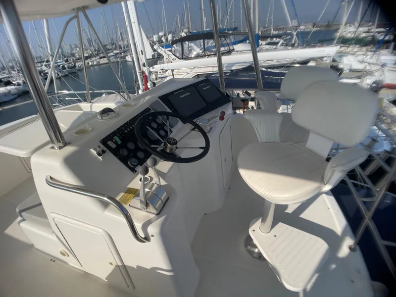 Slide: The Image of Flybridge helm of 2000 Riviera yacht with steering wheel and captain's chair in marina. - 13