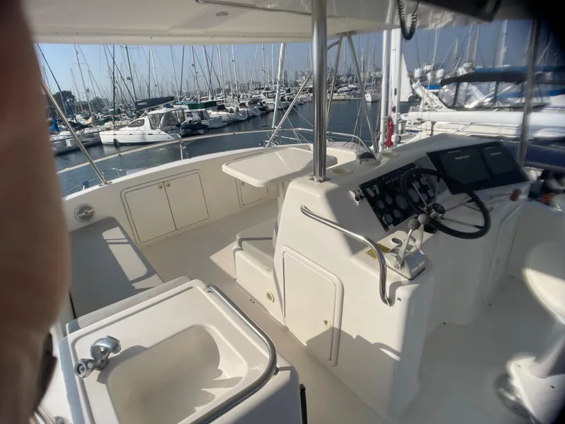 Slide: The Image of 2000 Riviera Flybridge yacht interior with helm, seating, and marina view. - 14