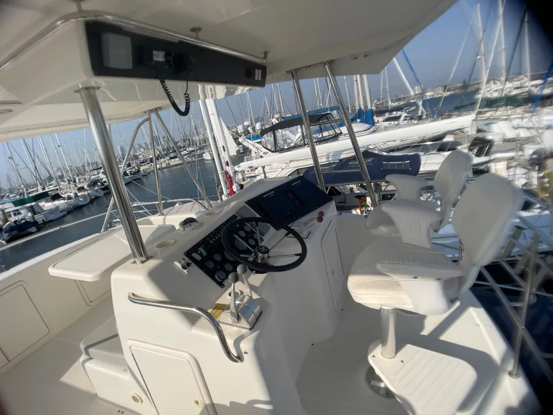 Slide: The Image of Flybridge of 2000 Riviera yacht with steering wheel and seating, docked at marina. - 17